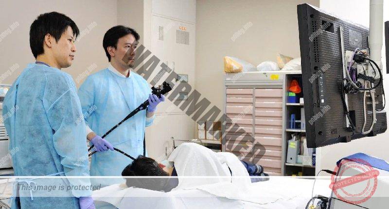 Два врачаь осматривают пациента в японской больнице