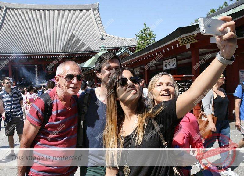 Туристы из Европы фотографируются в японском храме