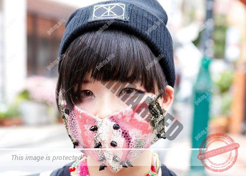 Японская девушка в розовой маске на лице