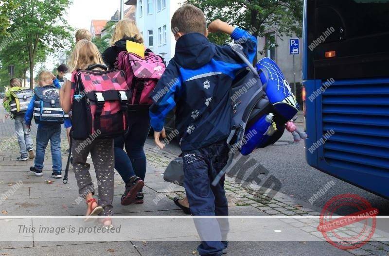 Немецкие дети идут в школу после автобуса, младшие классы